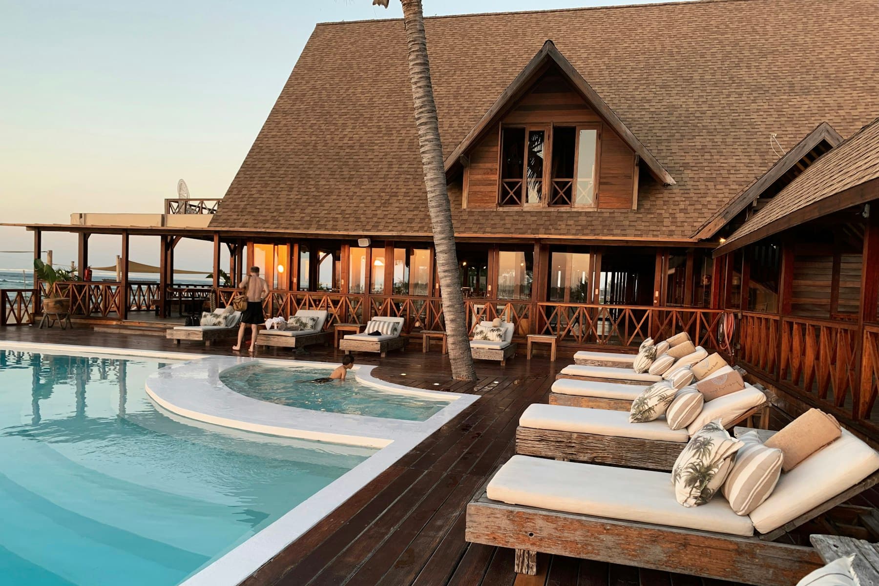 Resort pool with sun loungers in front of a hotel building