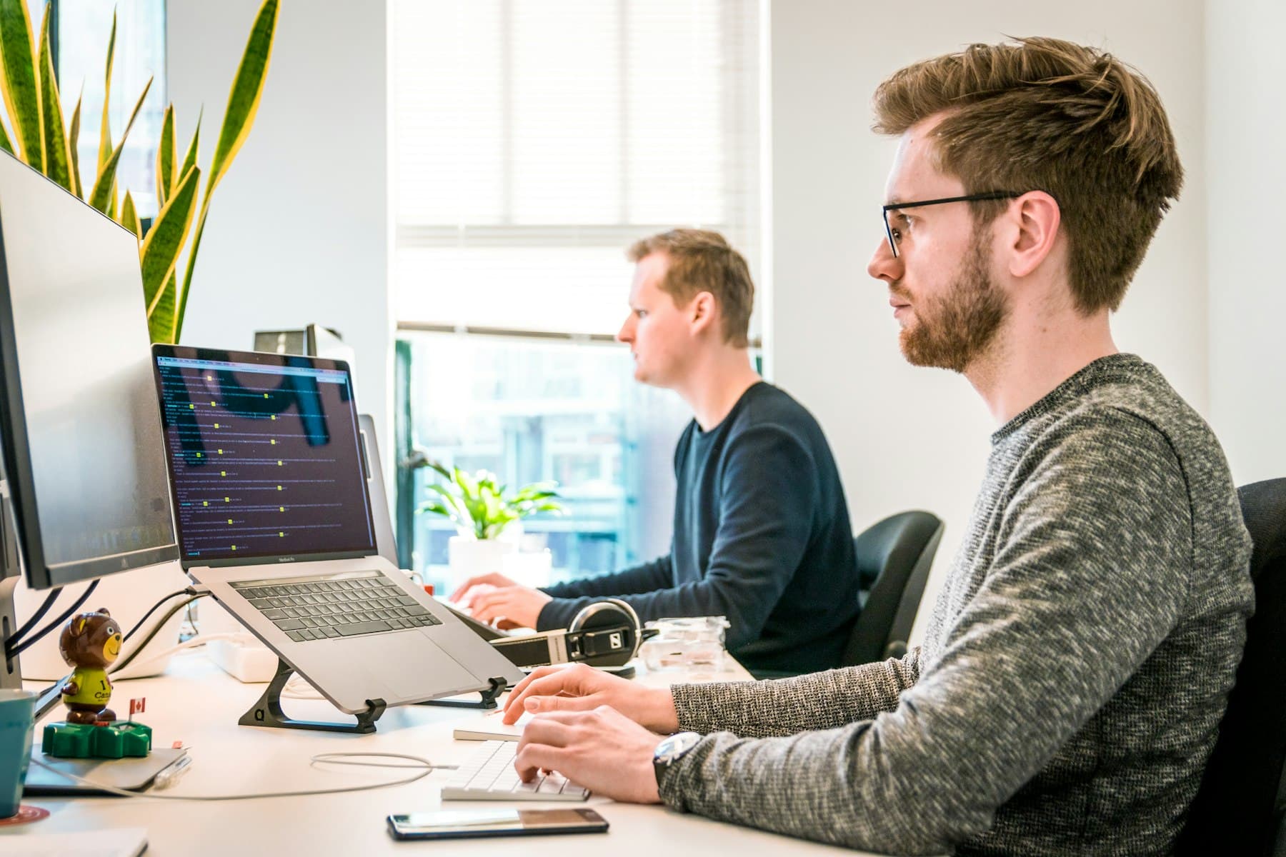 Developers working at desks with large monitors